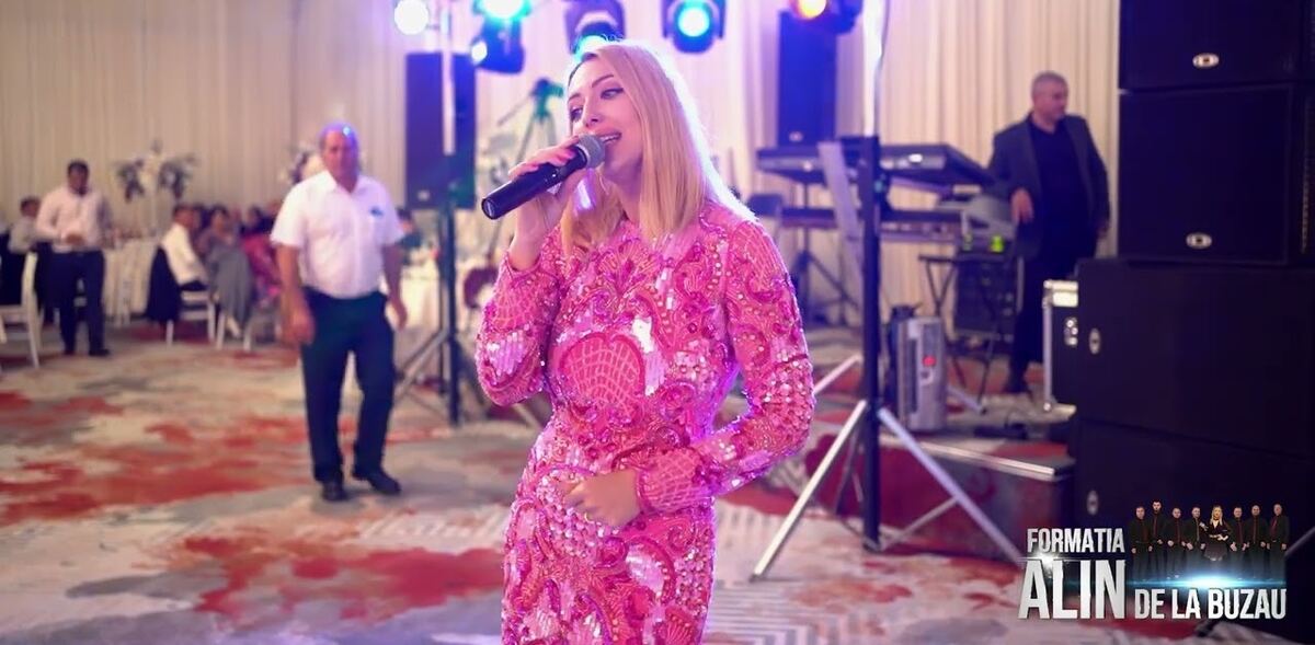 Solistă cântând live la un eveniment, în lumini de scenă